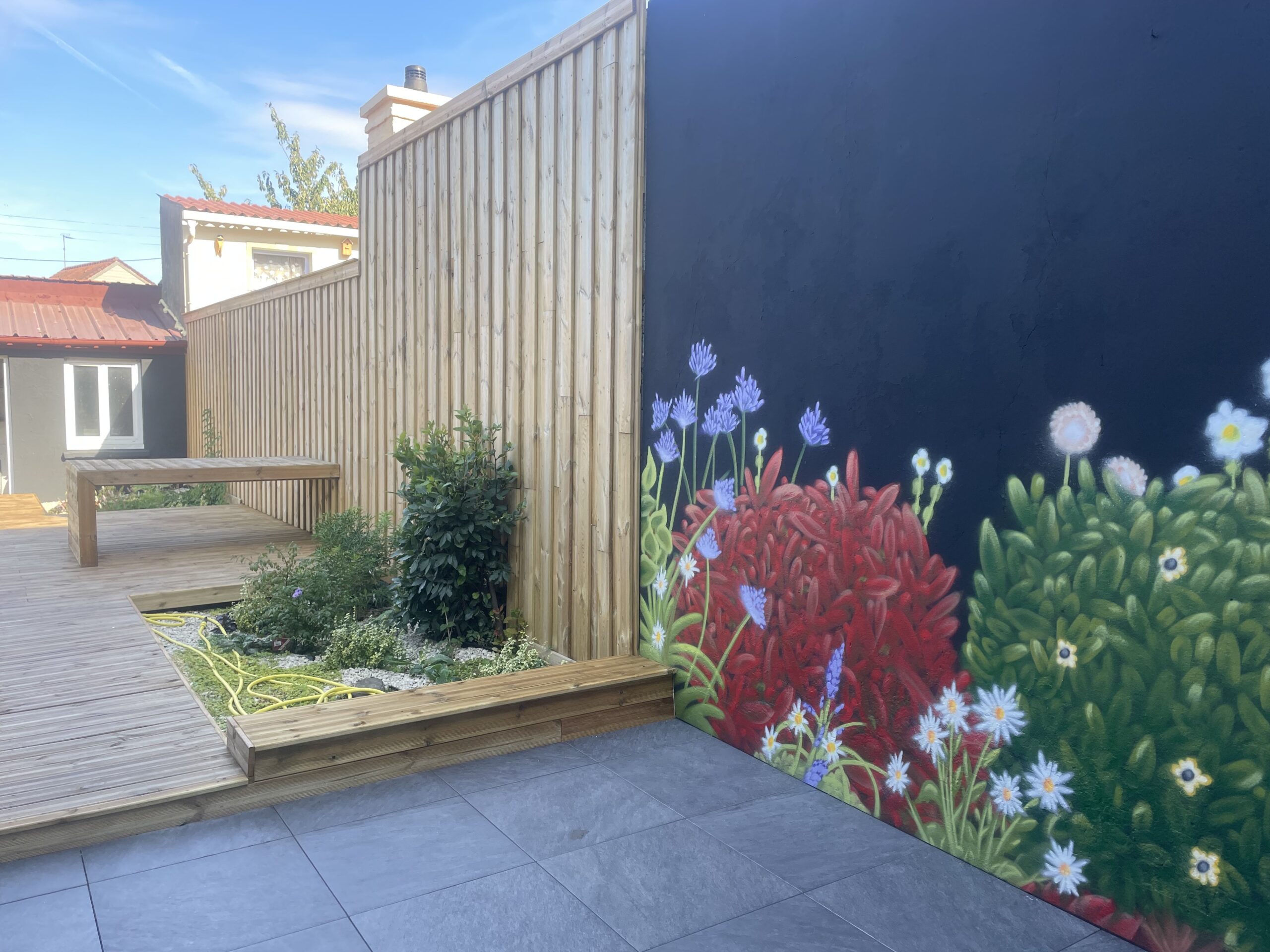 Graffiti végétal intégré dans un aménagement paysager avec terrasse